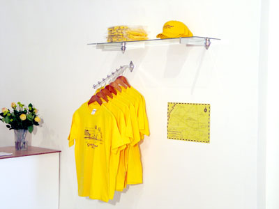 <i>Grand Detour Souvenir Installation</i>, 2006, baseball caps, T-Shirts, maps, Cds, catalogues, hanger, glass shelf and aluminum unit, aluminum store fixture